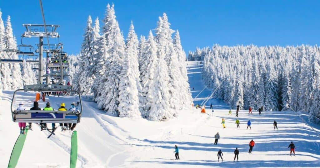 People on a ski lift chair going up a mountain