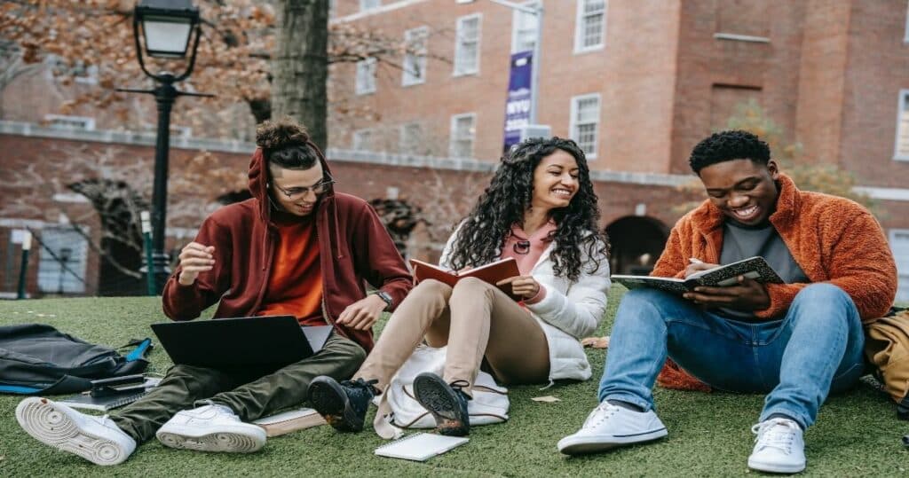 Students sitting on grass at a university campus