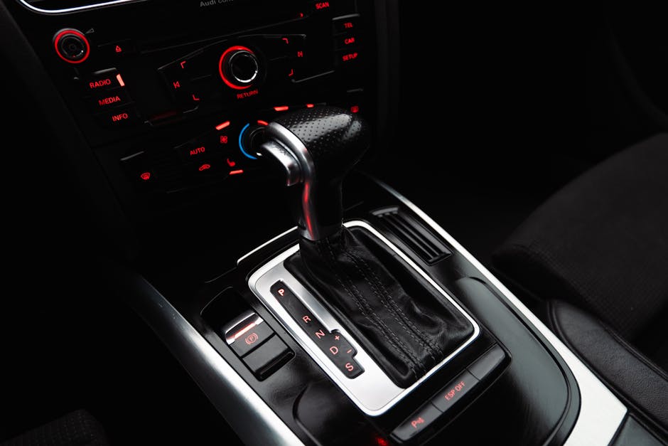 Close-up shot of a modern car gear shift lever and control panel, highlighting details.