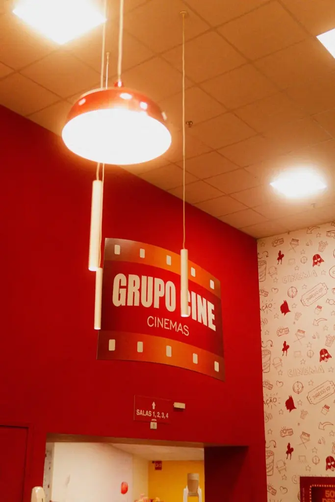 Red-themed cinema entrance with a vibrant Grupo Line sign and overhead lighting.