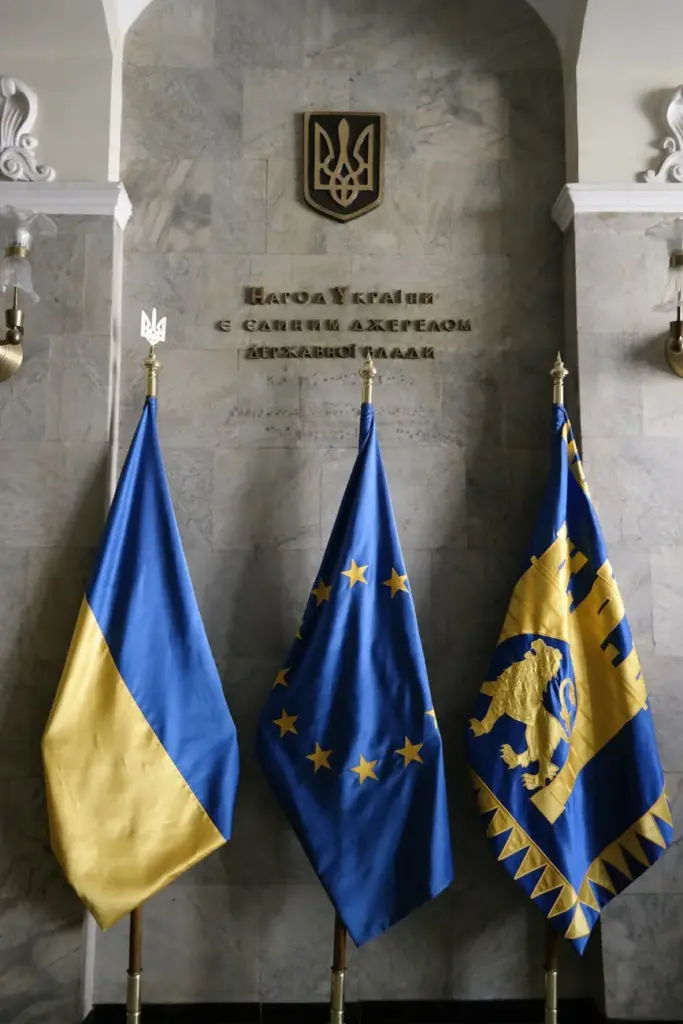 Ukrainian, EU, and Lviv flags displayed indoors in Lviv, Ukraine.