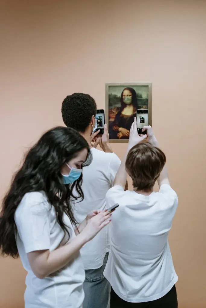 A group of people capturing a humorous, masked Mona Lisa painting with smartphones indoors.