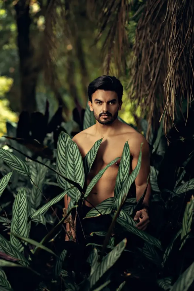 Topless man standing amidst lush tropical foliage in Porto Alegre.