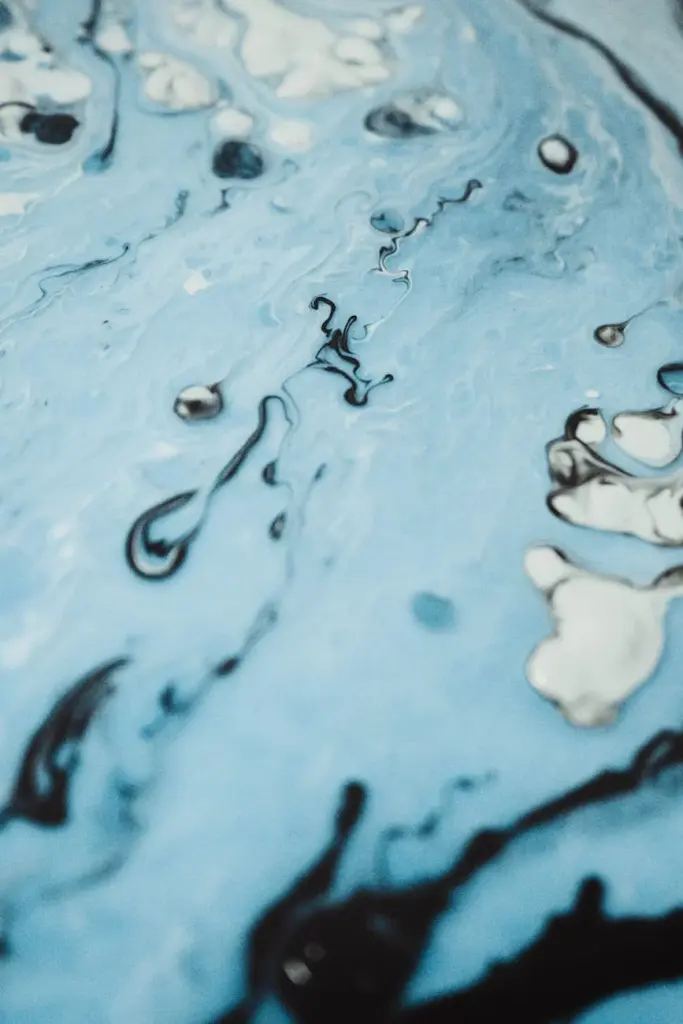Closeup detail of modern handicraft artwork made with blue paint with white and black stains