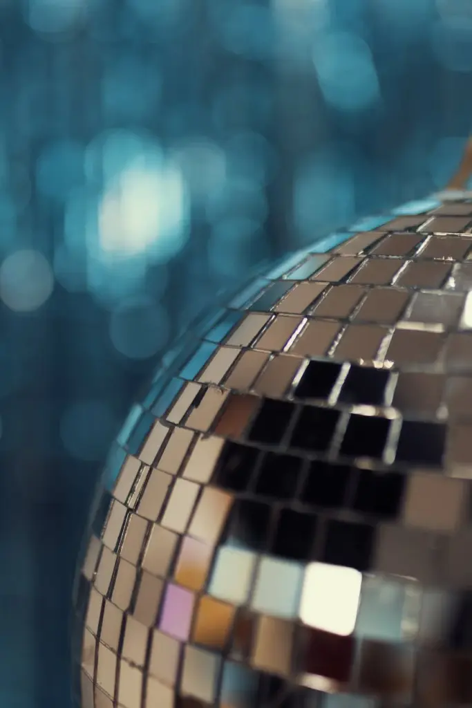 Captivating close-up of a sparkling disco ball with blue bokeh background, perfect for festive themes.