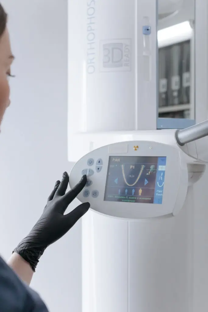 Dental technician using a modern 3D x-ray machine in a clinical setting.