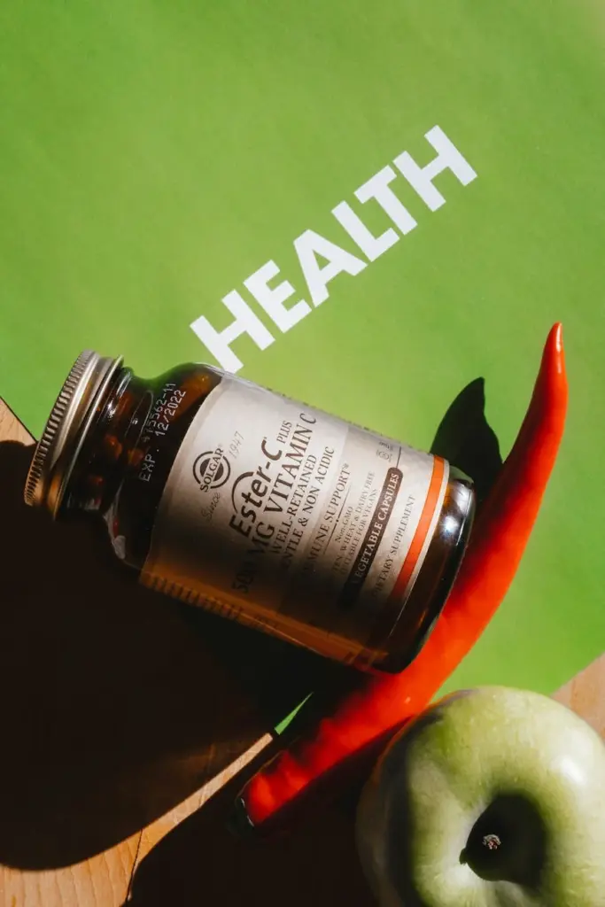 Vitamin C bottle surrounded by fresh produce on a green health-themed background.