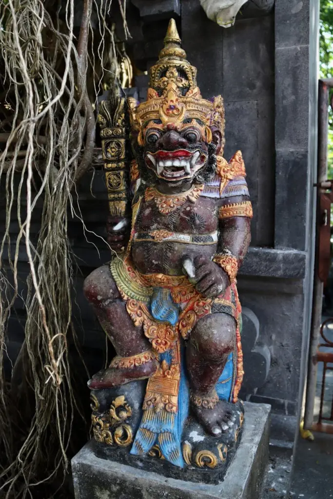 Colorful stone guardian statue in a Balinese temple, showcasing intricate traditional craftsmanship.