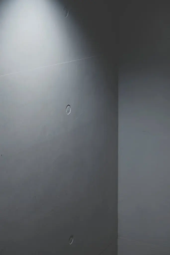 A minimalist concrete wall featuring soft lighting creates an abstract and modern atmosphere.