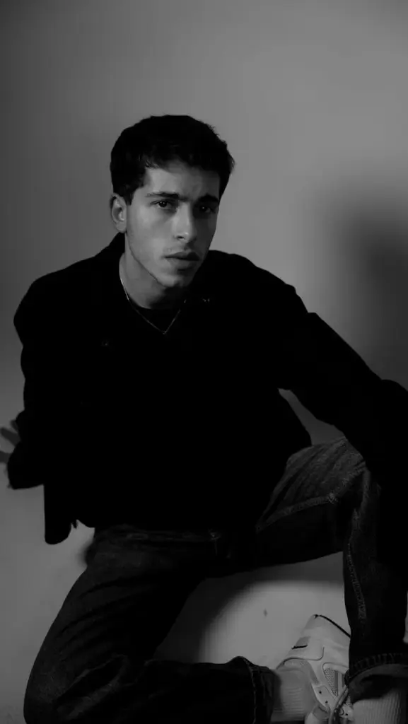 Moody black and white portrait of a young man in a studio setting
