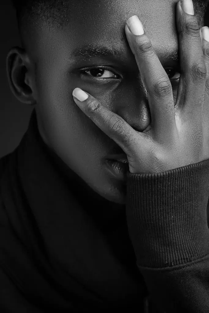 Expressive portrait of a young man in black and white with a contemplative gaze.