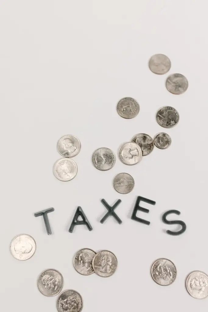Conceptual image of scattered coins representing taxes and finance on a white background.