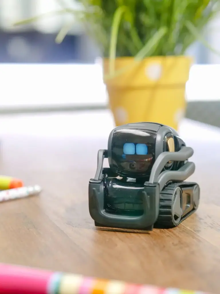 Close-up of a small robot toy on a desk, representing modern technology and innovation.
