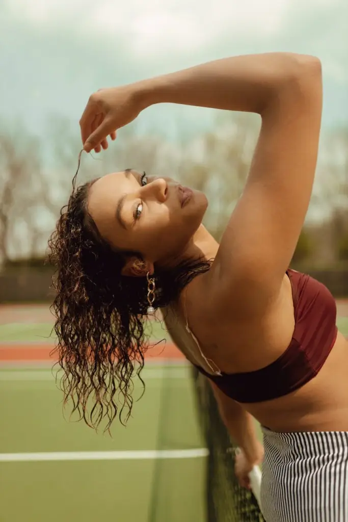 Fashionable woman posing on a tennis court in Des Moines, showcasing modern casual style.