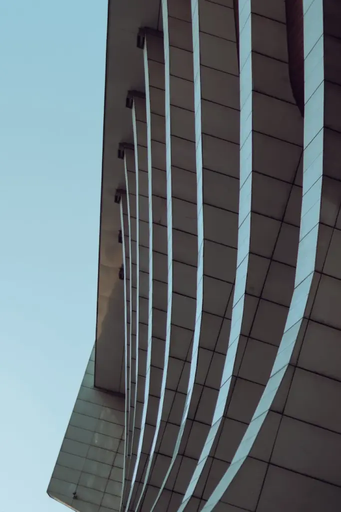 Modern building facade with a clear blue sky background, showcasing sleek architectural design.