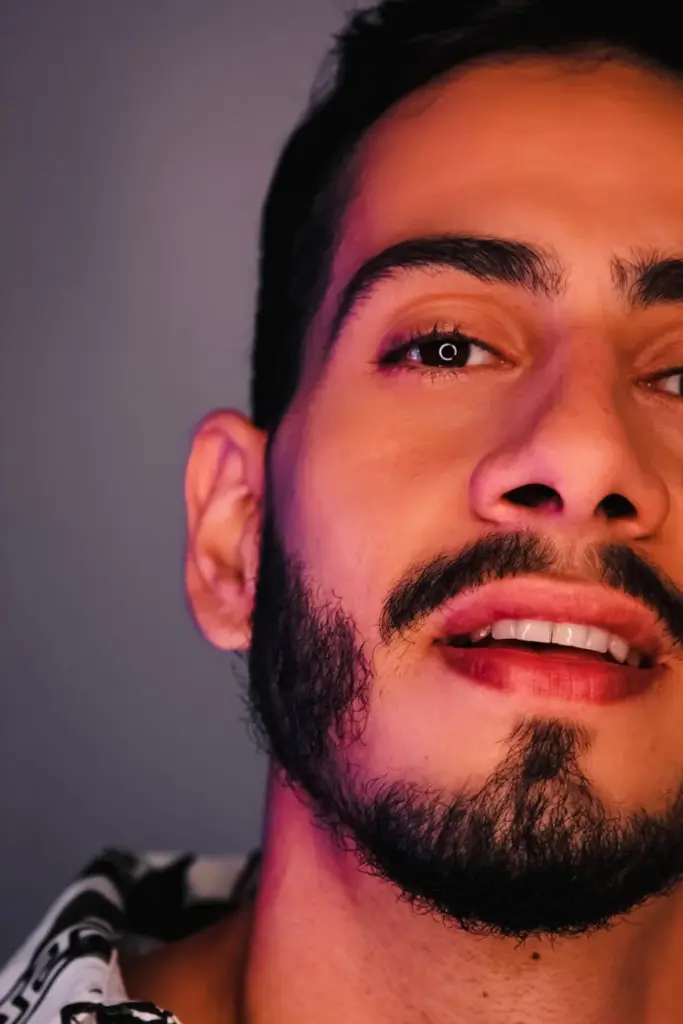 Close-up of a man with facial hair against an artistic backdrop. Captivating expression.
