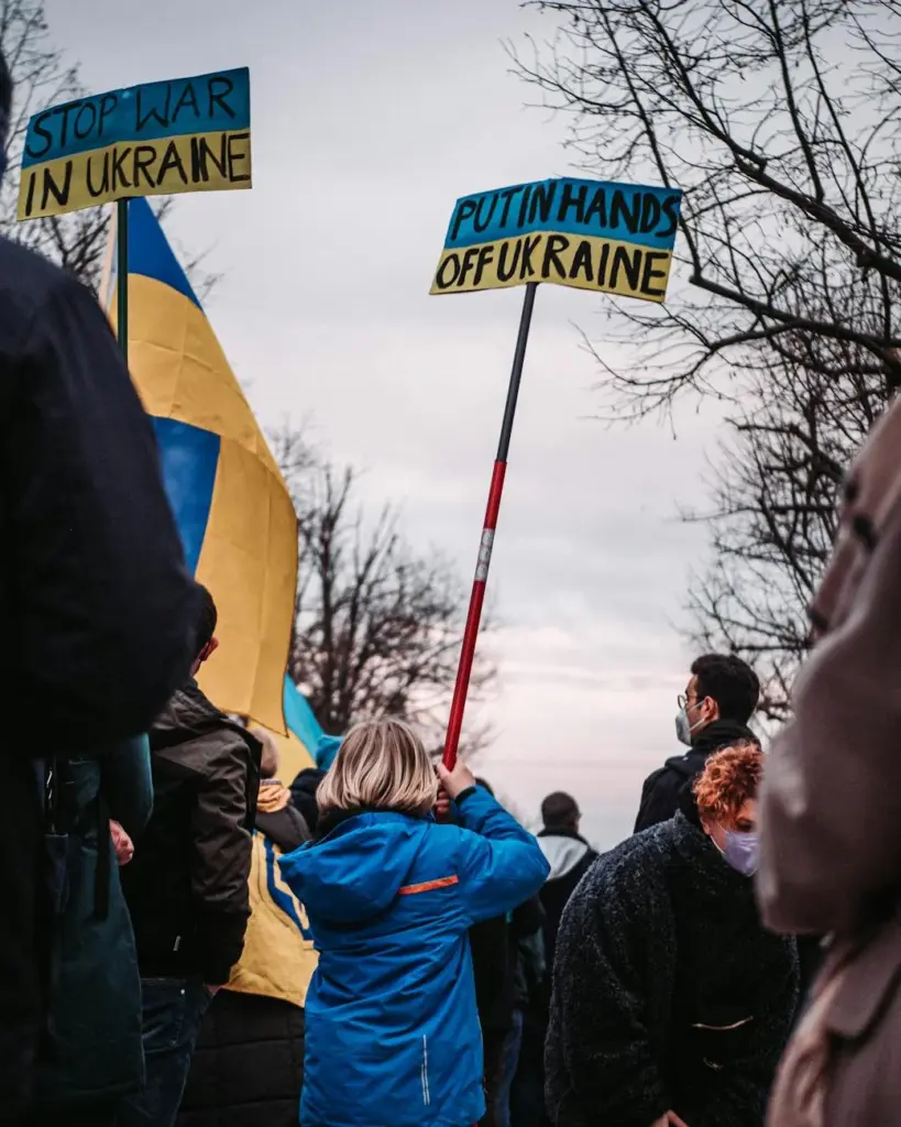 Demonstrators in Berlin advocate peace for Ukraine with signs and flags on a winter day.