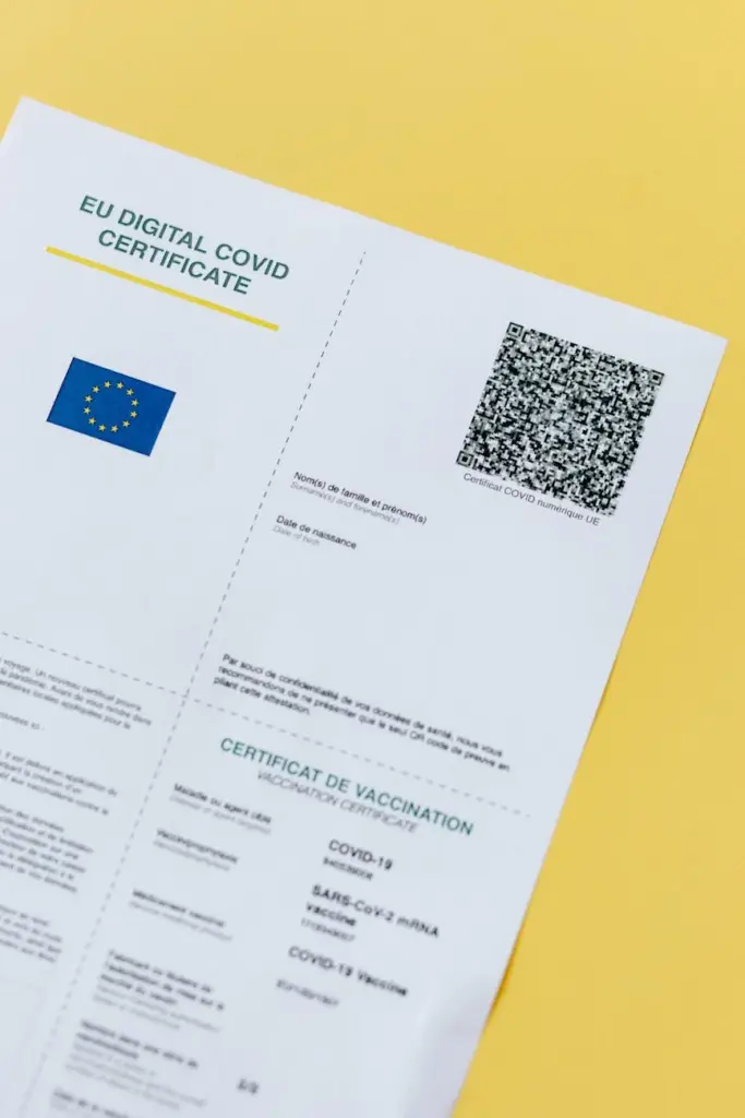 Close-up of an EU Digital COVID Certificate with QR code on a yellow background.