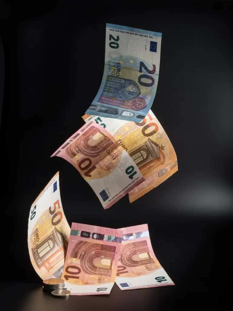 Euro banknotes floating gracefully on black background, symbolizing wealth and currency.