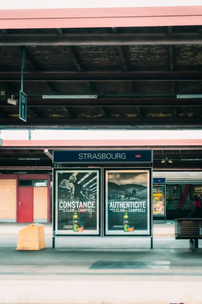 View of Strasbourg train station showcasing billboards and platform.