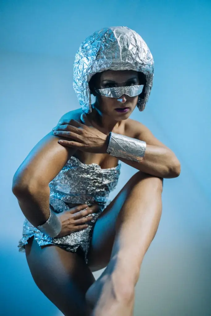 A studio shot of a futuristic woman in a cyberpunk style aluminum foil outfit with a sci-fi vibe.