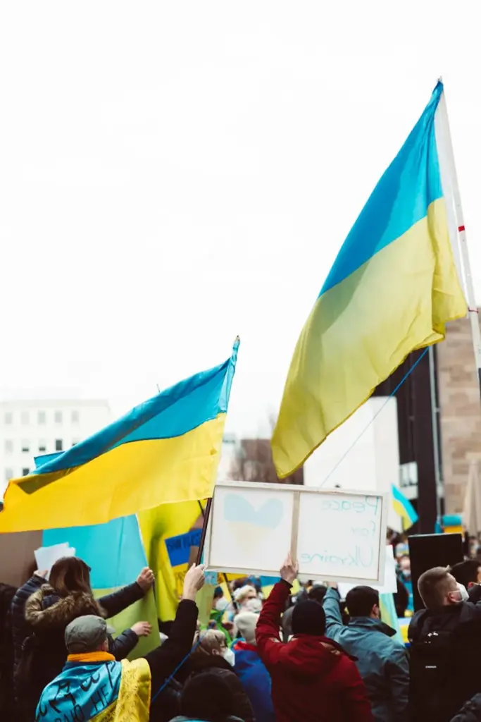 Group of people rallying with Ukrainian flags, showing patriotism and support.