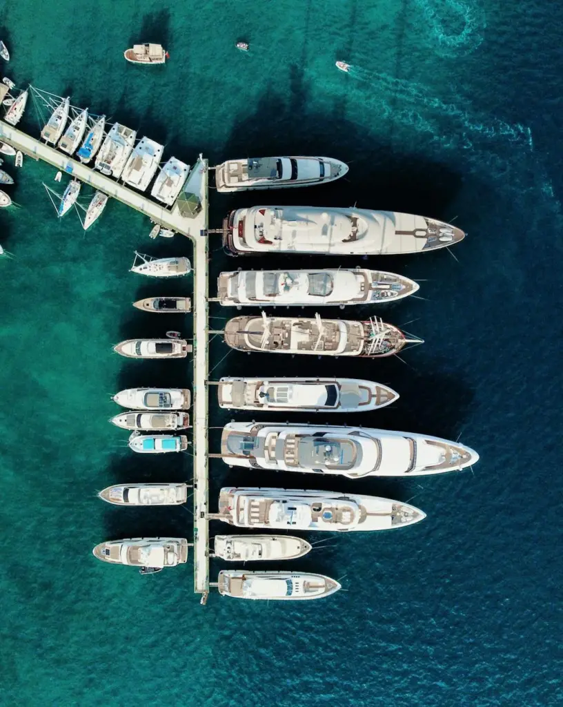 Top view of yachts moored at a marina in clear blue waters.