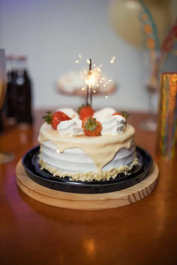 Celebrate with a vibrant Brazilian cake, topped with strawberries and sparklers, perfect for birthdays.