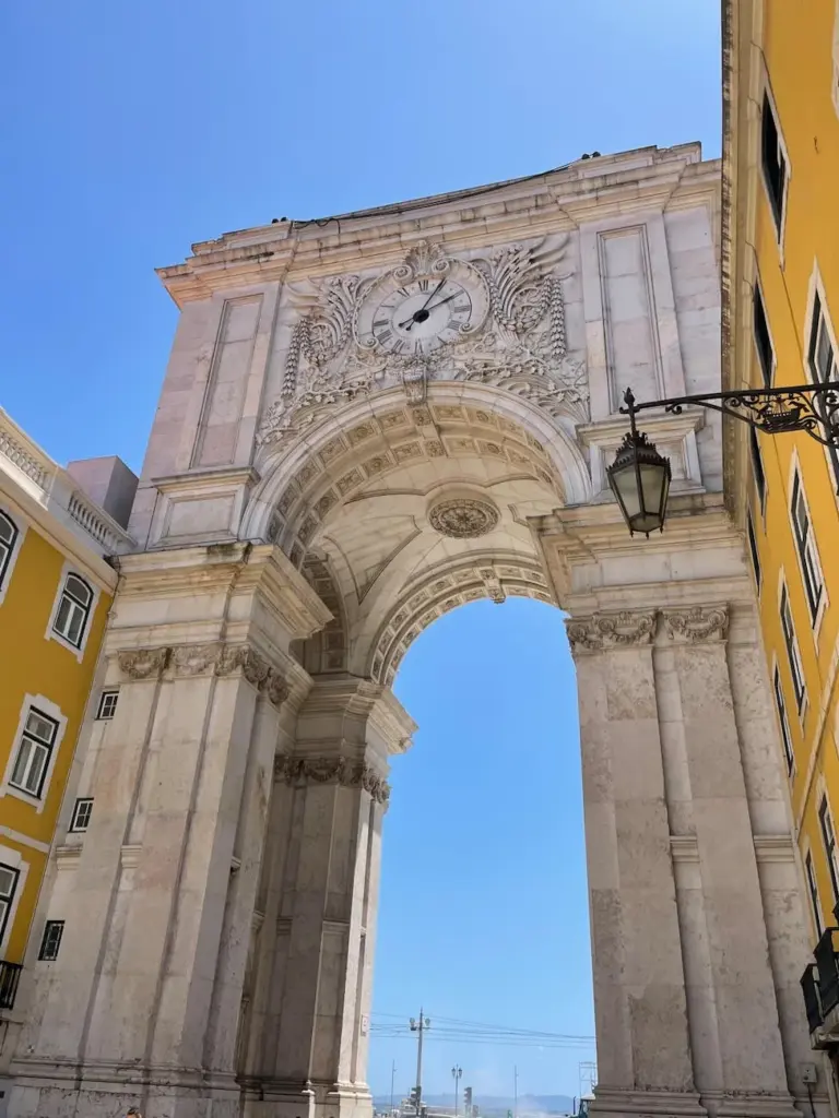 A stunning view of the Arco da Rua Augusta, a historical monument in Lisbon, Portugal, under a bright summer sky.
