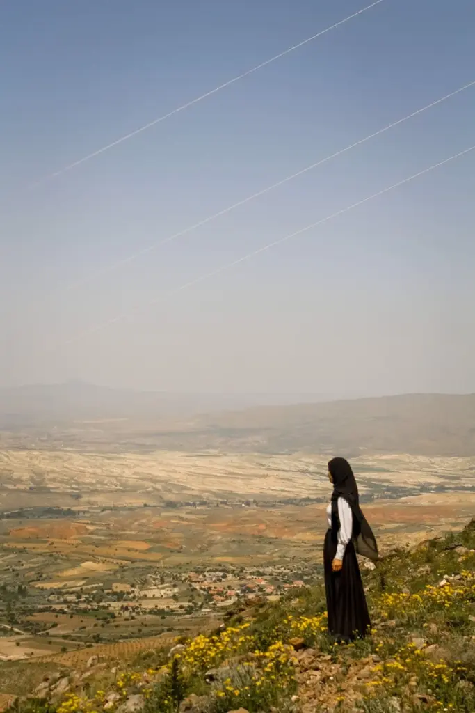 Woman in hijab overlooking scenic mountains in Türkiye. Ideal for travel and landscape themes.