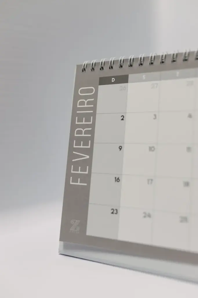 Close-up of a desk calendar displaying February in Portuguese, on a neutral background.