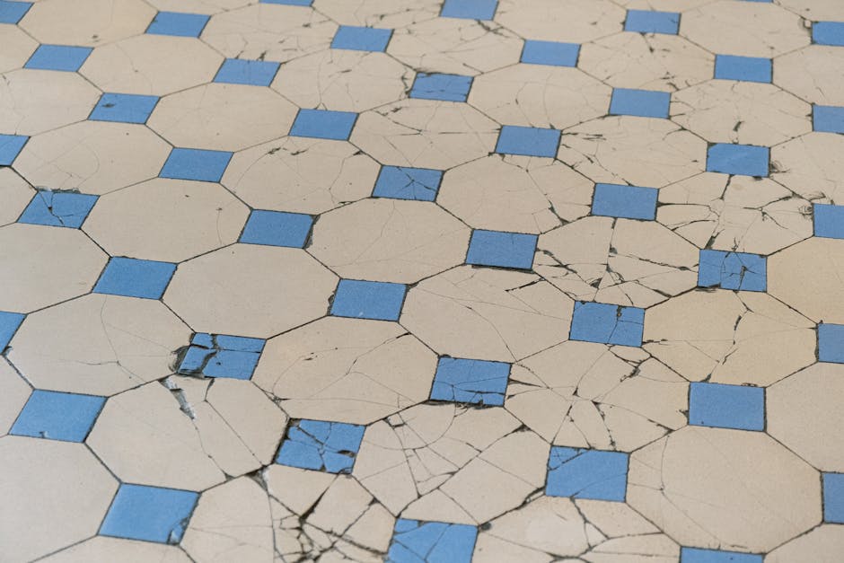 A detailed view of aged cracked tiles with a blue and white geometric pattern.