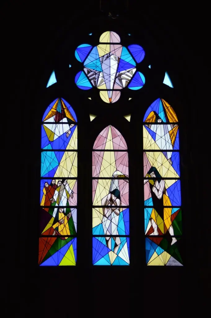Colorful stained glass window in a church depicting religious scenes.