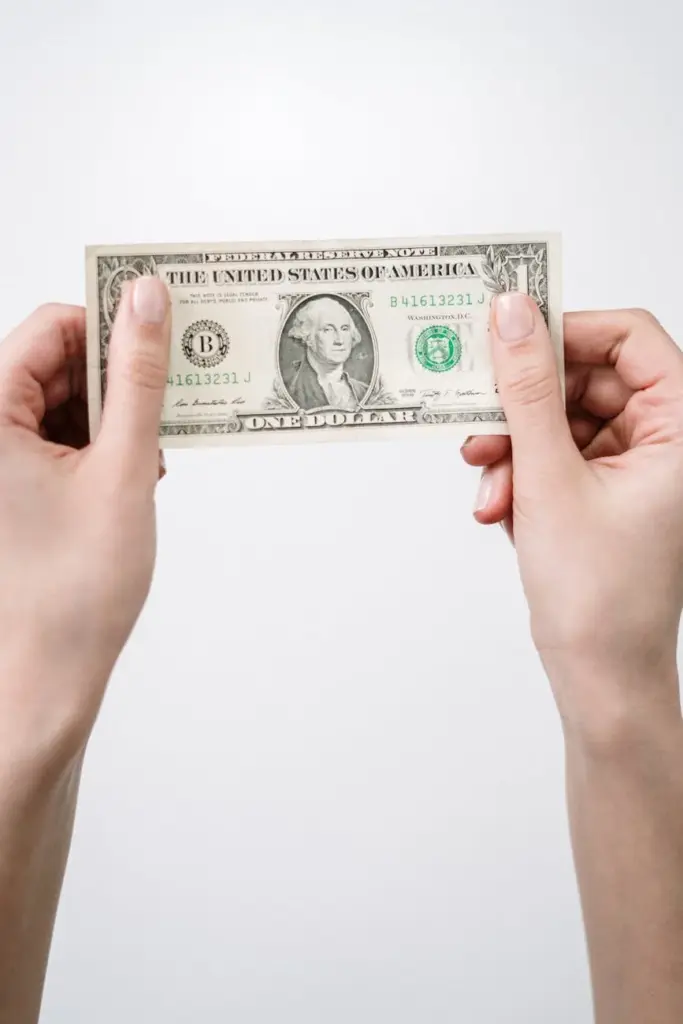 Close-up of hands holding a one dollar bill, symbolizing finance and currency.