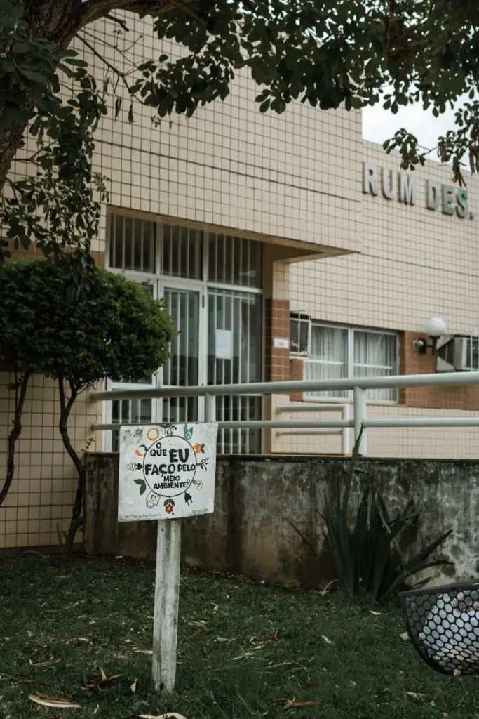 Tiled building facade with a sign promoting environmental awareness in Alto Rio Novo, Brazil.