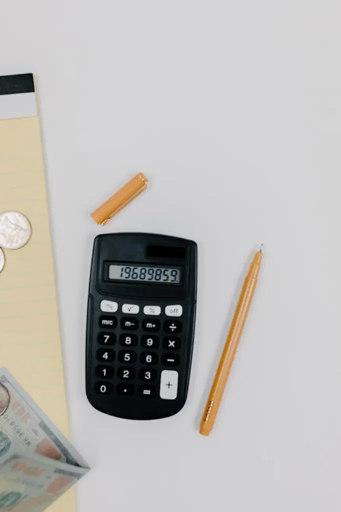 Top view of calculator, pen, and notepad for office work.