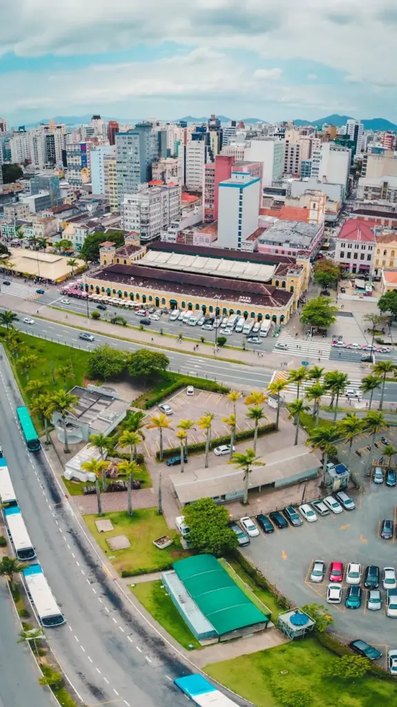 Aerial view of Florianópolis cityscape showcasing roads, buildings, and greenery.