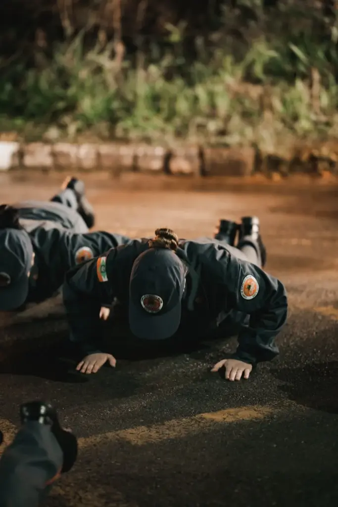 Police officers in uniform doing push-ups outdoors at night, showcasing strength and teamwork.