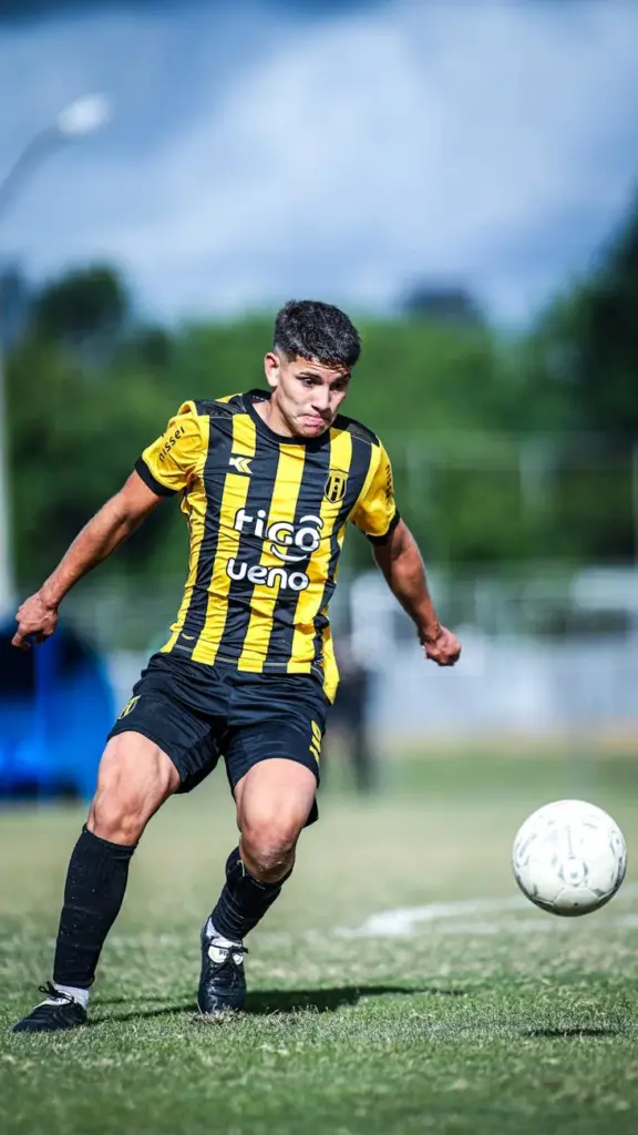 Soccer player in motion on the field in a competitive match.