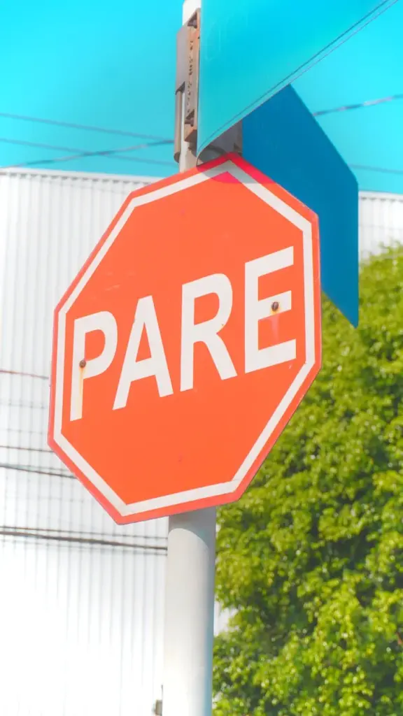 Vibrant red 'Pare' stop sign on a sunny day in Jundiaí, Brazil.