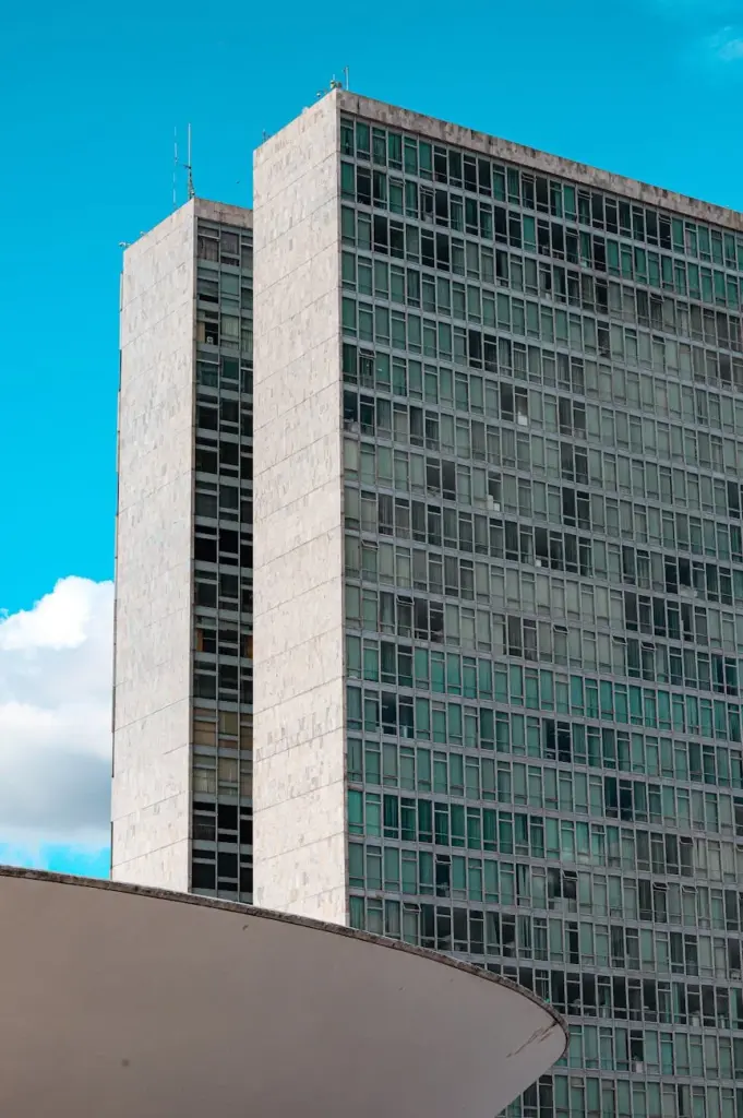 Majestic multi storey identical building above white round decorative construction under vibrant blue sky
