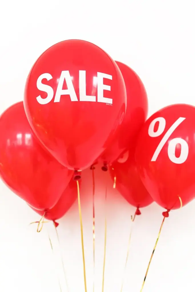 Bright red balloons with sale and percentage symbols for promotional advertising.