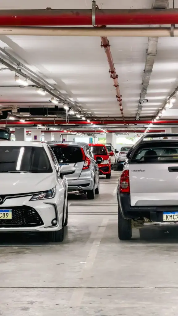 A busy underground parking lot filled with various cars lined up in designated spots.