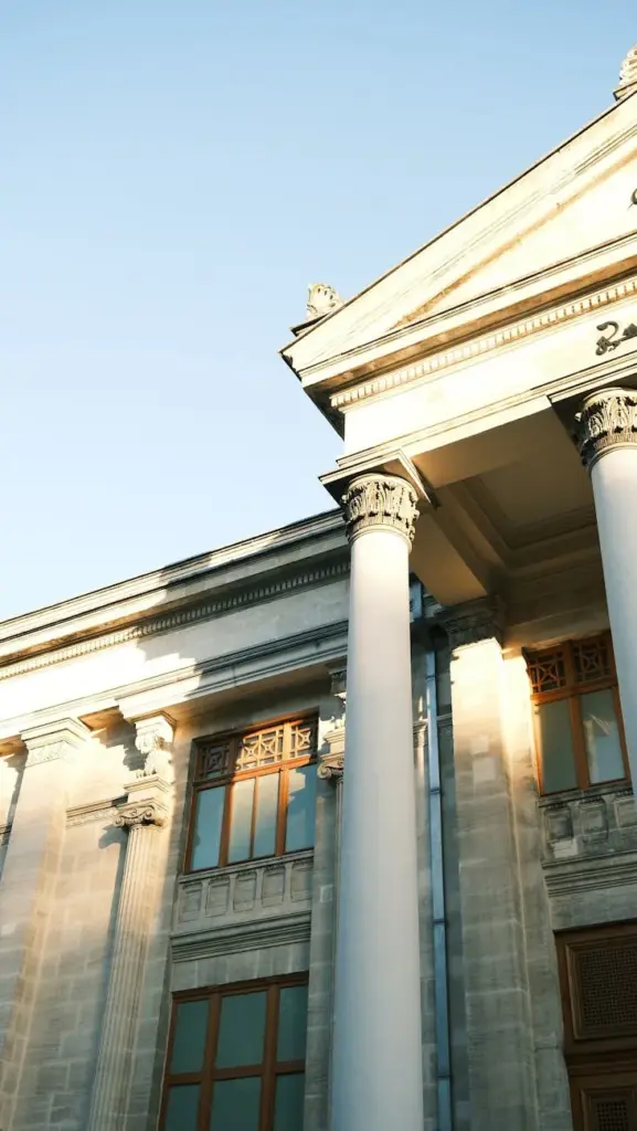 Elegant neoclassical architecture with sunlit columns and detailed facade.