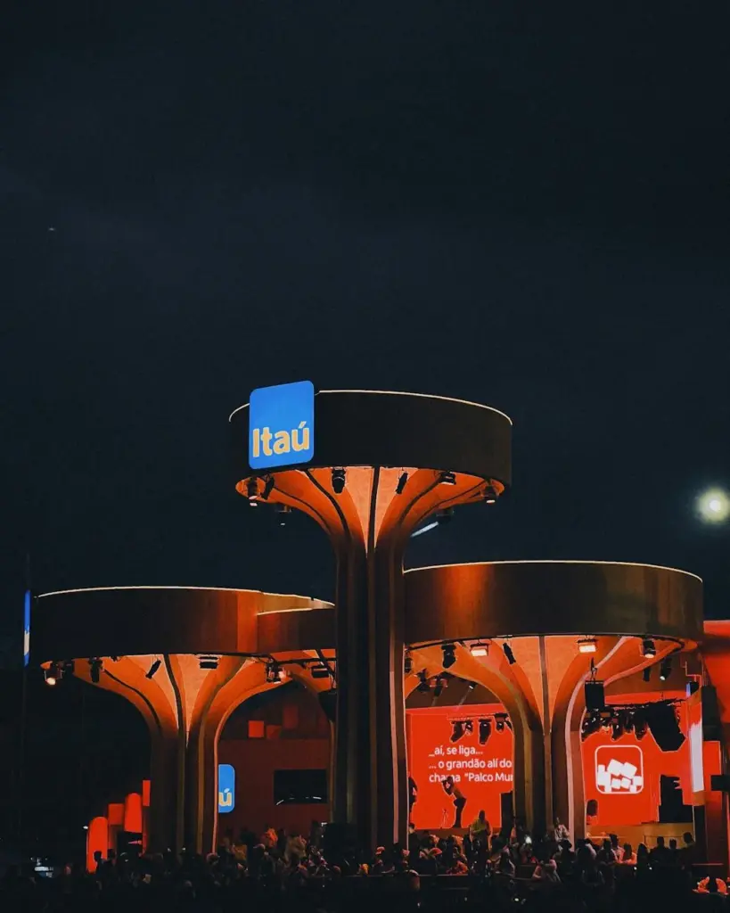 A striking night view of an illuminated Itaú event structure with crowd and modern lighting.