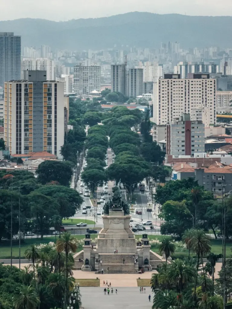 Dramatic aerial view of São Paulo skyline with lush greenery and vibrant city life.