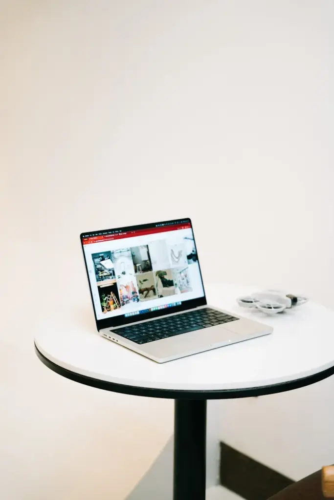 Modern laptop on a round table with a minimalist background, perfect for office or cafe scenes.
