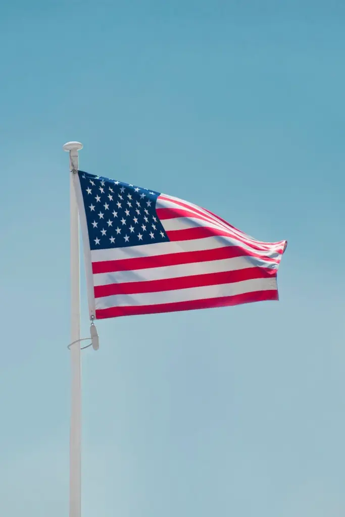 A vibrant American flag waves against a clear blue sky in Washington, DC.