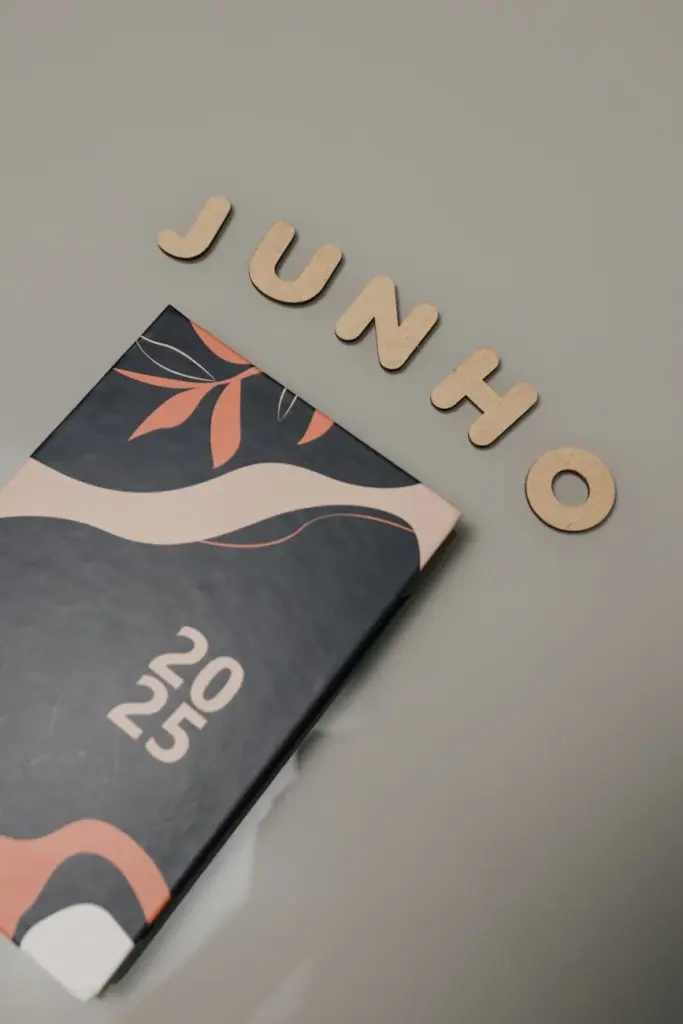 Minimalist 2025 planner with artistic cover design, alongside June spelled out in wooden letters.