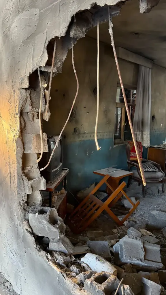 A heavily damaged room with debris, revealing past destruction.